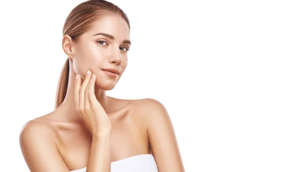A Woman in front of white background holding hands on cheeks | clearlift™-treatment | Instinct Holistic Medical Spa